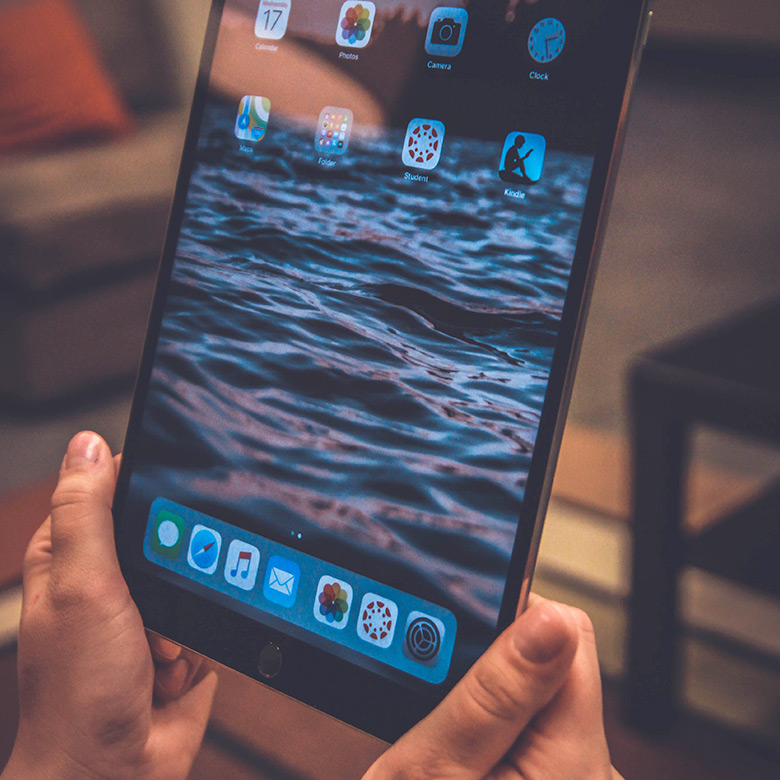 Mains tenant une tablette tactile
