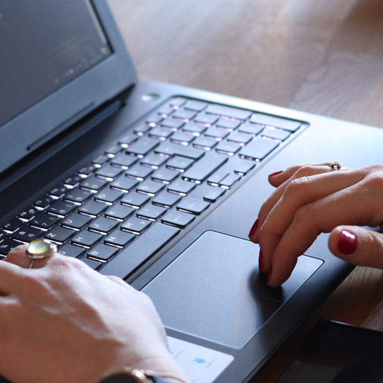 Mains sur le clavier d'un ordinateur portable